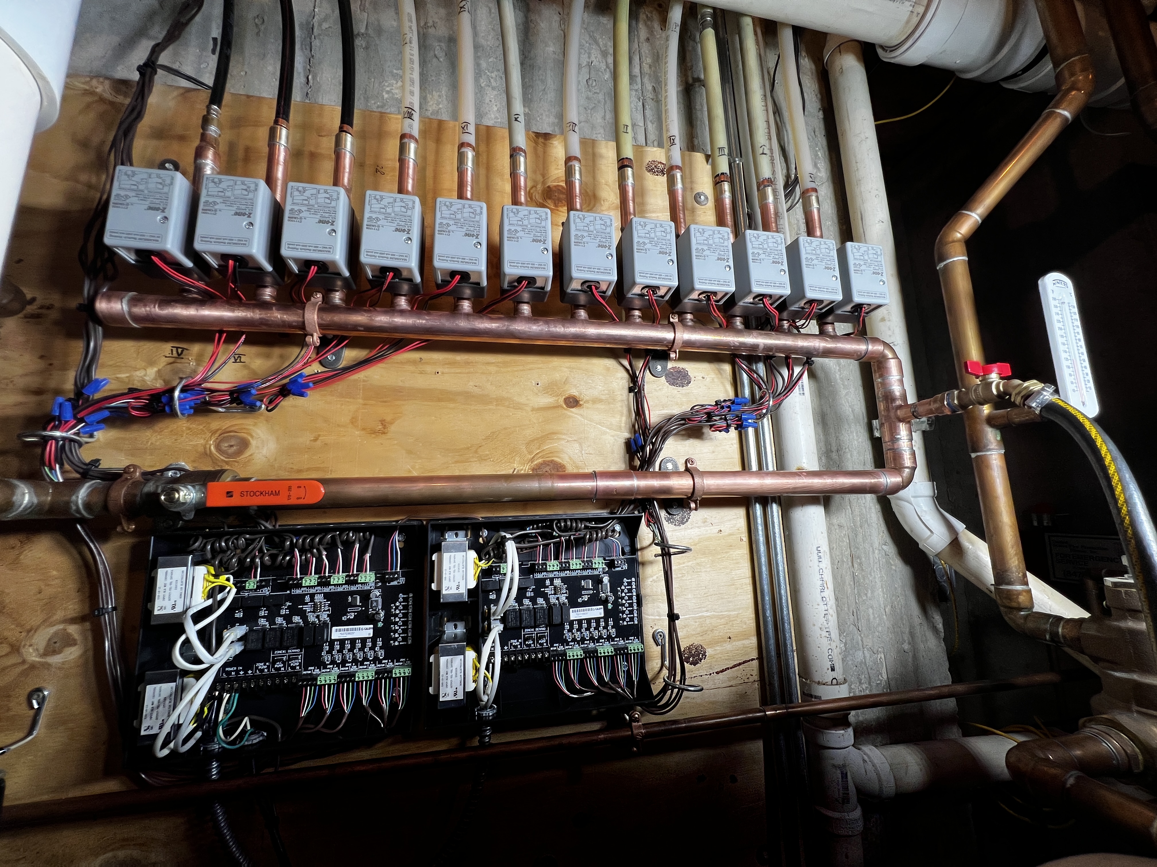 Copper hydronic headers with a row of zone valves and two control panels
